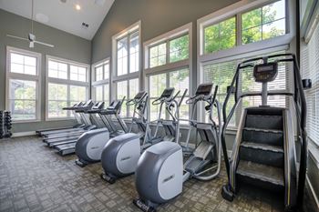 A gym with treadmills and elliptical machines.